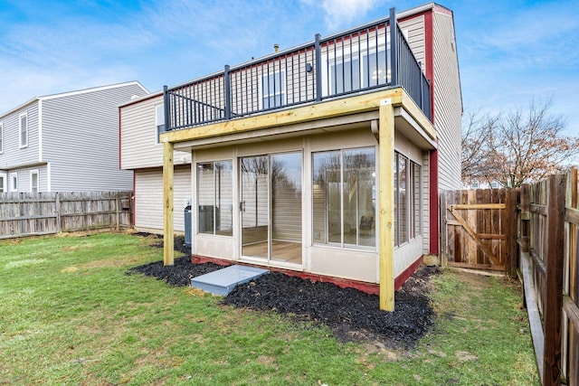 back of house featuring a fenced backyard and a lawn