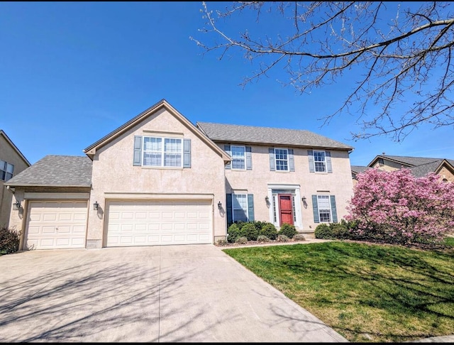 view of front facade featuring driveway, a front yard, and stucco siding