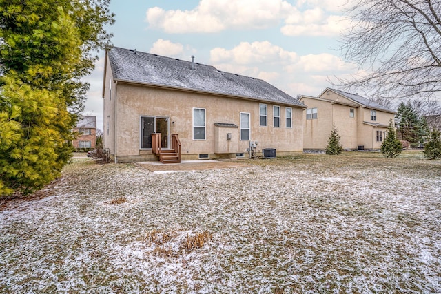 back of property with central AC unit and stucco siding