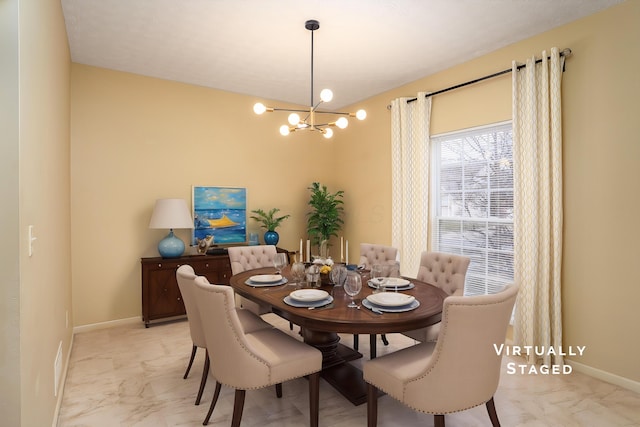 dining space featuring marble finish floor, baseboards, and an inviting chandelier