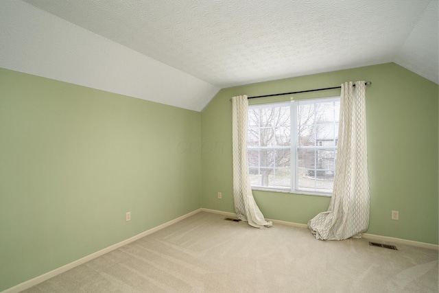 bonus room with a textured ceiling, carpet, and visible vents