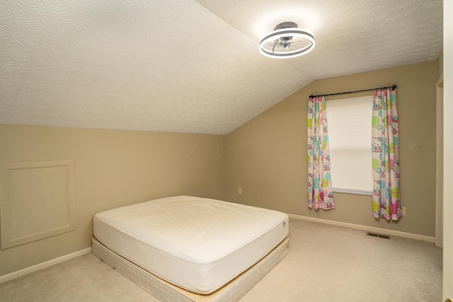 bedroom featuring a textured ceiling, light carpet, visible vents, baseboards, and vaulted ceiling