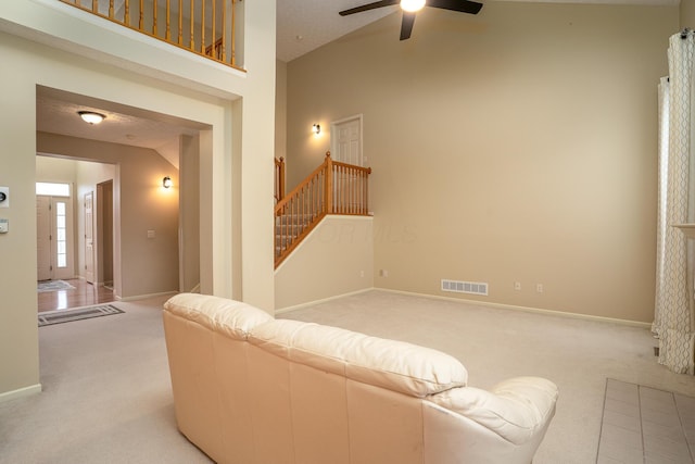 living area featuring light carpet, stairs, visible vents, and baseboards