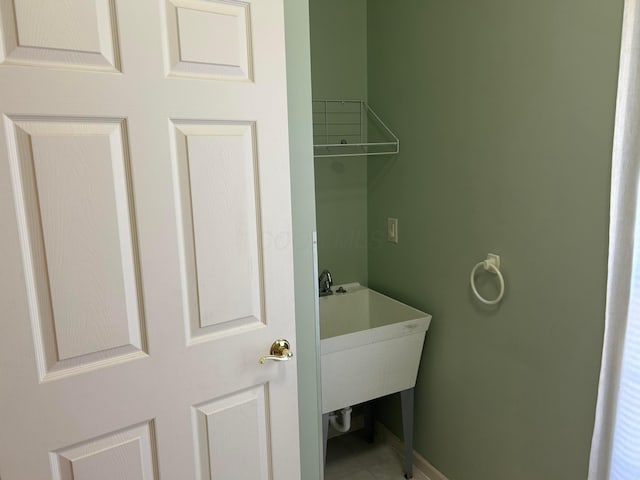 clothes washing area with baseboards