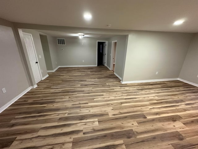 basement with baseboards, visible vents, and wood finished floors