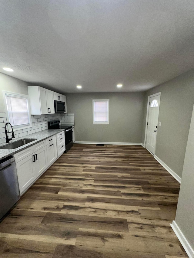 kitchen featuring white cabinets, appliances with stainless steel finishes, dark wood finished floors, and a sink