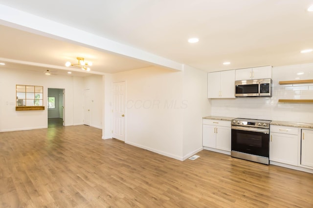 kitchen featuring white cabinets, light wood-style floors, backsplash, and stainless steel appliances