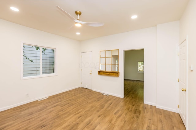 empty room with visible vents, baseboards, light wood-style floors, and a ceiling fan