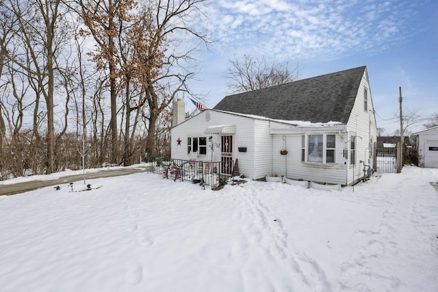 view of front of home with a shingled roof and a chimney