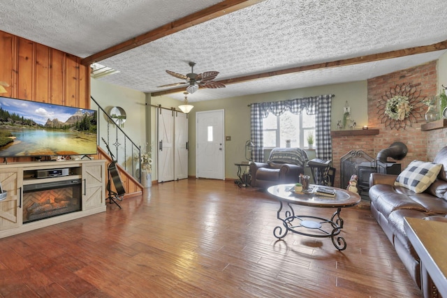 living room with a fireplace, wood finished floors, and beam ceiling