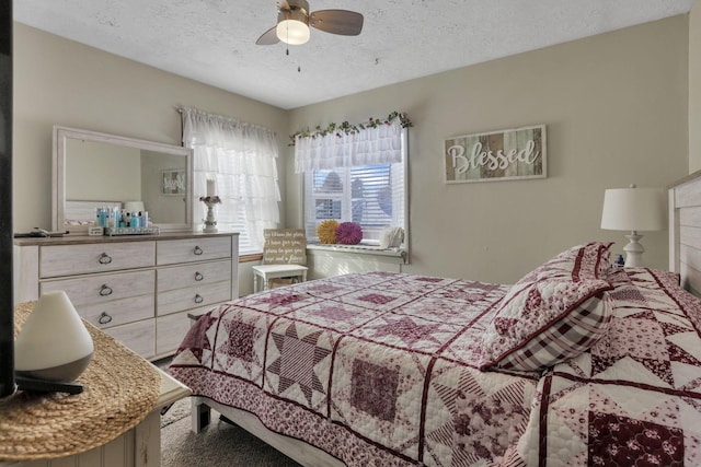 bedroom with a textured ceiling and a ceiling fan