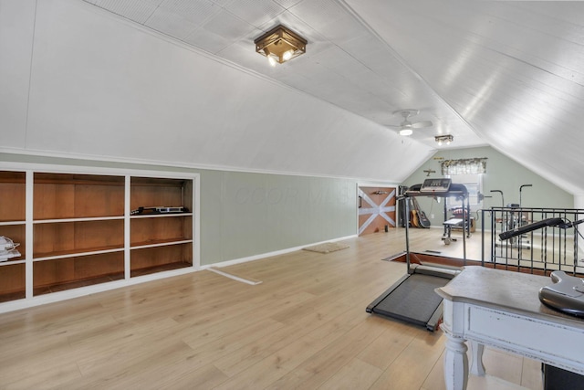 workout area featuring lofted ceiling and wood finished floors