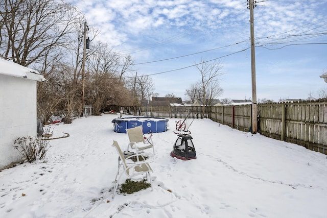 yard layered in snow with a fenced backyard