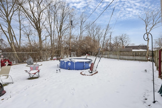 snowy yard featuring fence