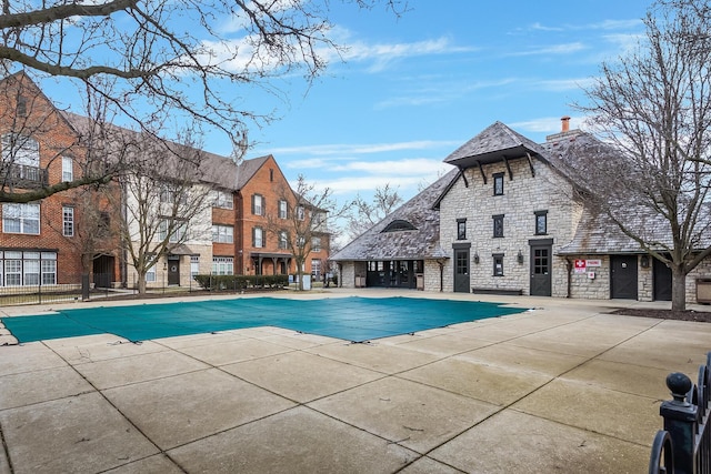 pool with a patio area and fence