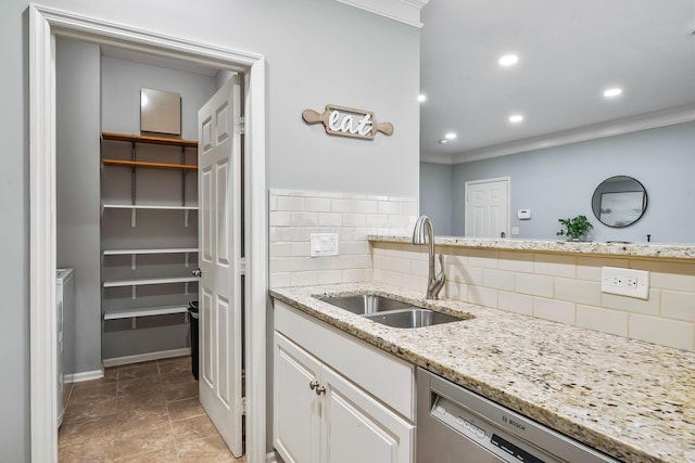 kitchen featuring white cabinets, dishwasher, decorative backsplash, crown molding, and a sink