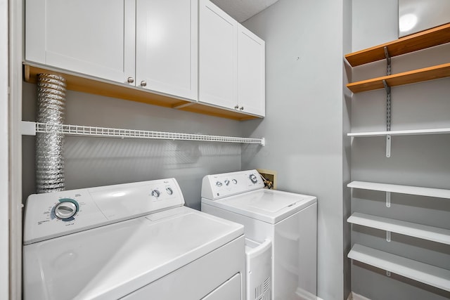 washroom featuring cabinet space and independent washer and dryer