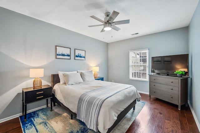 bedroom featuring a ceiling fan, wood finished floors, visible vents, and baseboards