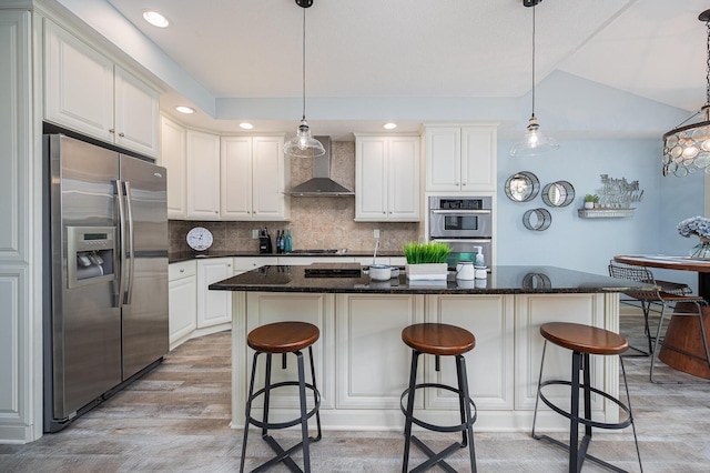 kitchen featuring appliances with stainless steel finishes, wall chimney range hood, white cabinetry, and tasteful backsplash