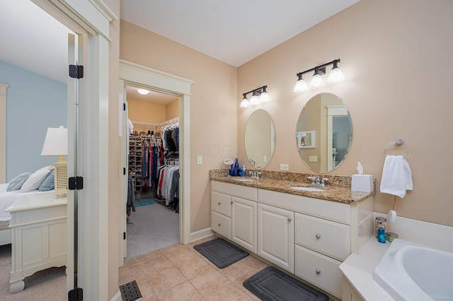 ensuite bathroom with ensuite bathroom, visible vents, vanity, a spacious closet, and tile patterned floors