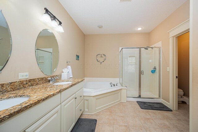 full bathroom featuring a garden tub, a stall shower, a sink, and tile patterned floors