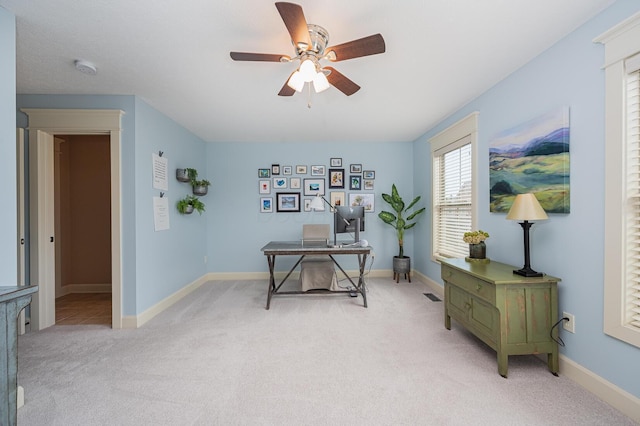 office with light carpet, baseboards, visible vents, and a ceiling fan