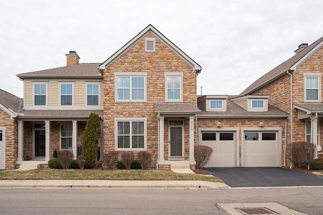 view of front facade with a garage, aphalt driveway, and roof with shingles