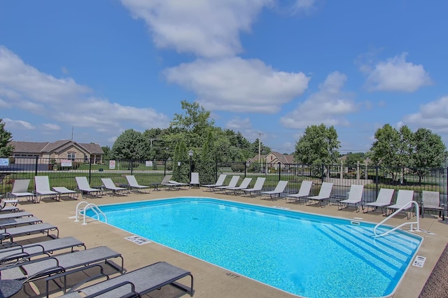 pool with a patio and fence