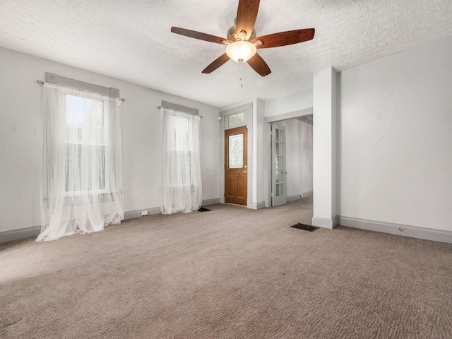 spare room with baseboards, visible vents, a textured ceiling, and carpet flooring