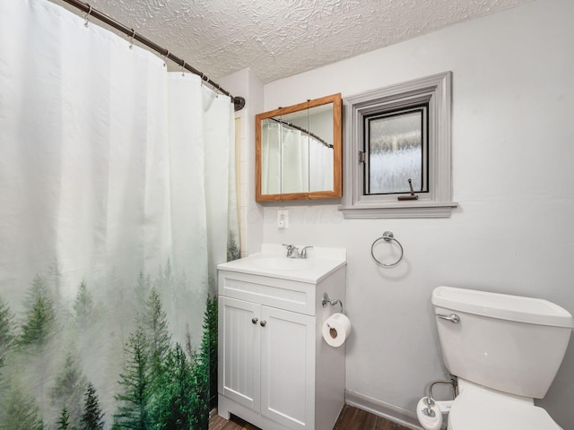 full bathroom with toilet, wood finished floors, curtained shower, a textured ceiling, and vanity