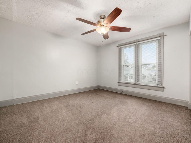 carpeted empty room with ceiling fan, baseboards, and a textured ceiling