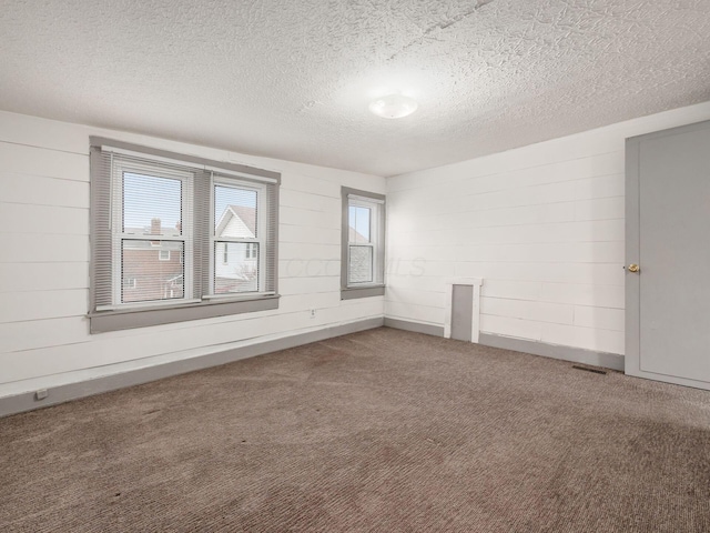 carpeted spare room with a textured ceiling and visible vents