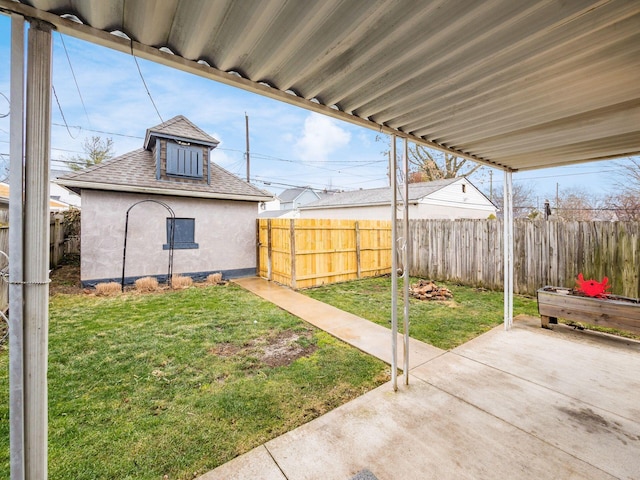 view of yard featuring fence, an outbuilding, and a patio