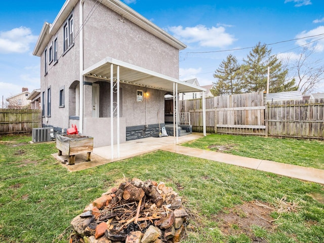 rear view of house featuring a yard and stucco siding