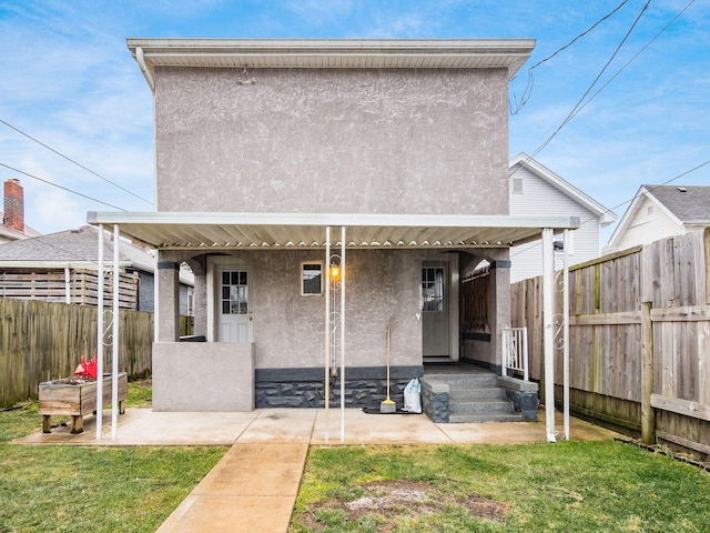 back of property with a yard, a fenced backyard, a patio area, and stucco siding