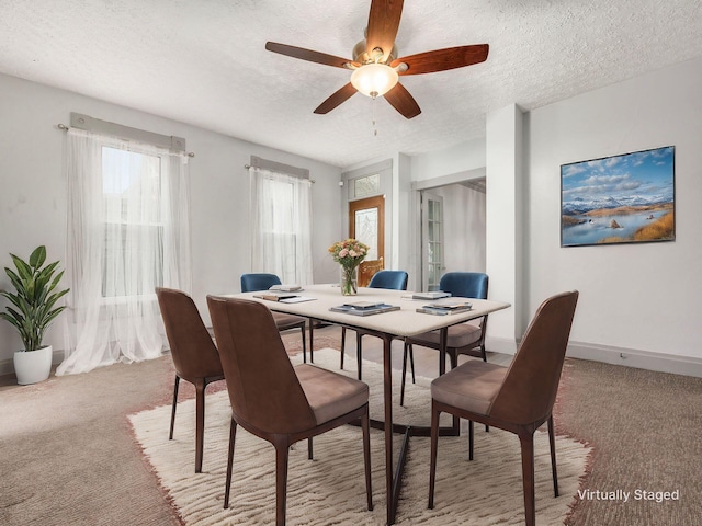 carpeted dining space with a ceiling fan, a textured ceiling, and baseboards