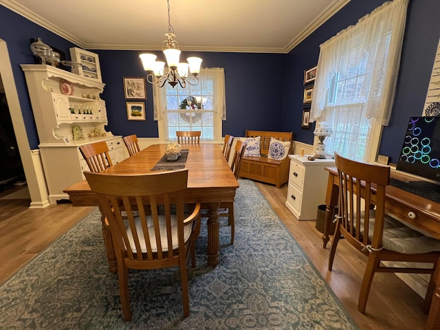 dining room featuring a chandelier, light wood-style floors, and ornamental molding