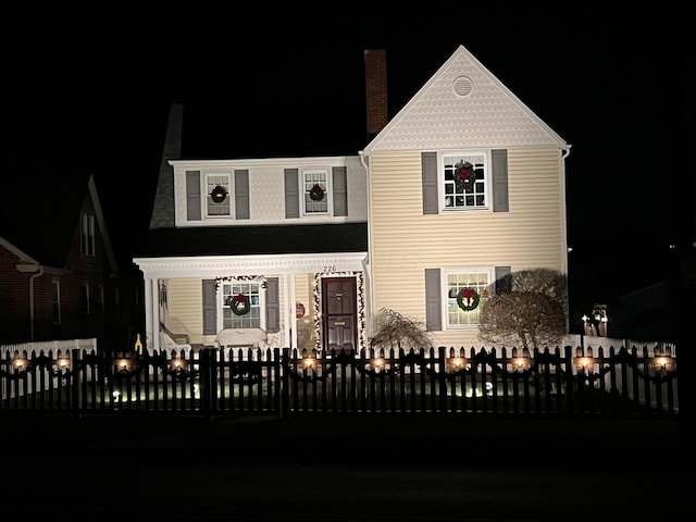 view of front of house with a fenced front yard and a chimney