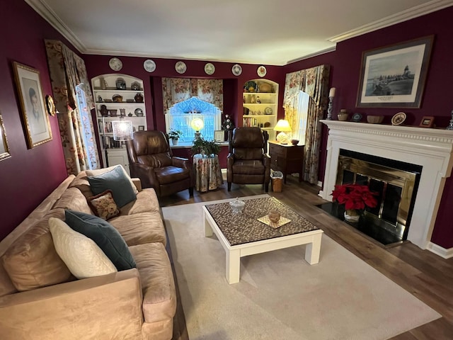 living room with built in features, a fireplace with flush hearth, wood finished floors, and crown molding