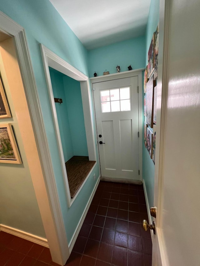 interior space with dark tile patterned floors and baseboards