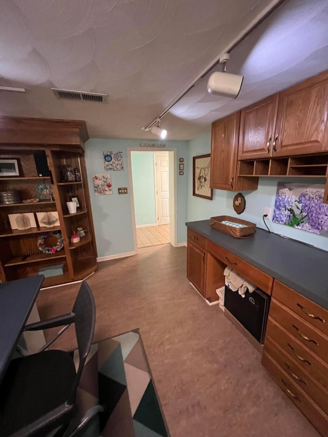 office space featuring visible vents, rail lighting, built in study area, and baseboards