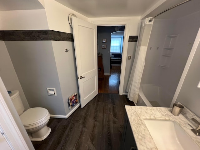 bathroom featuring vanity, toilet, wood finished floors, and baseboards