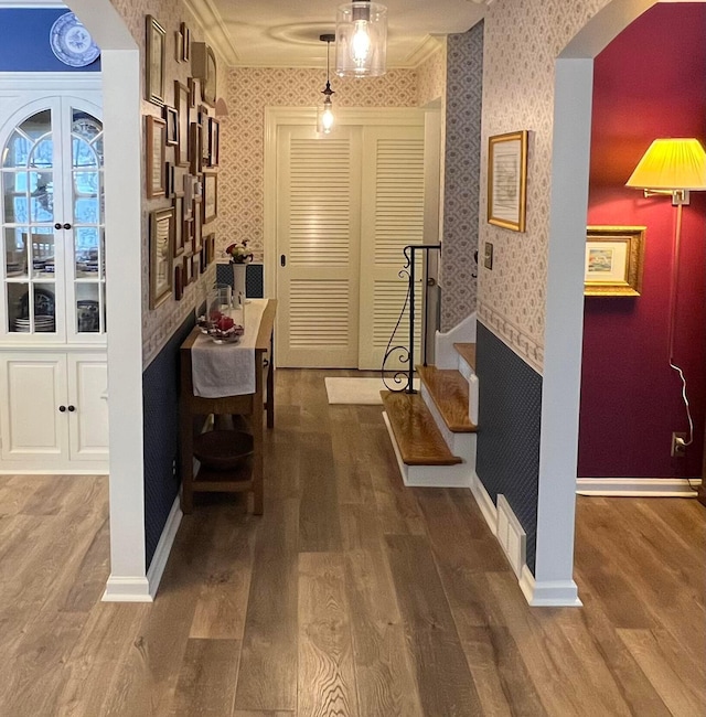 hall with baseboards, wood finished floors, and wallpapered walls