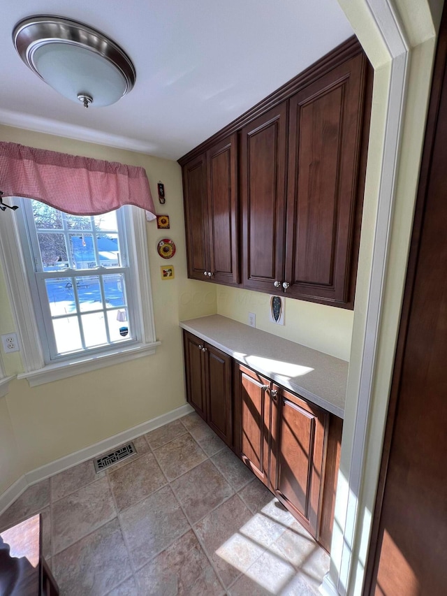 kitchen featuring visible vents, baseboards, and dark brown cabinets