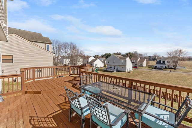 wooden terrace with a residential view, a lawn, and outdoor dining space