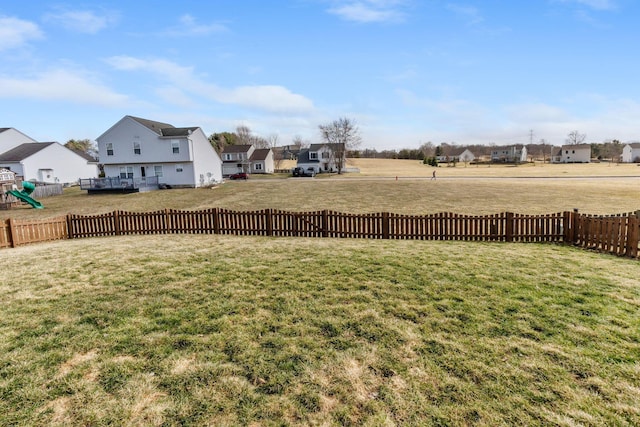 view of yard featuring a residential view, a playground, and fence