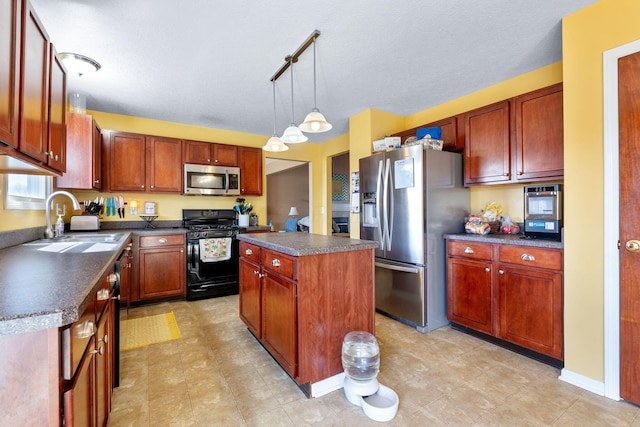 kitchen featuring dark countertops, a kitchen island, appliances with stainless steel finishes, pendant lighting, and a sink