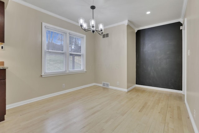 unfurnished dining area featuring baseboards, ornamental molding, visible vents, and light wood-style floors