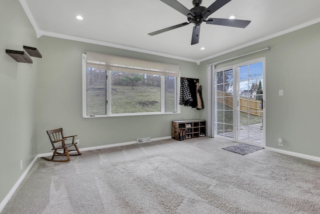 carpeted spare room featuring visible vents, baseboards, and crown molding