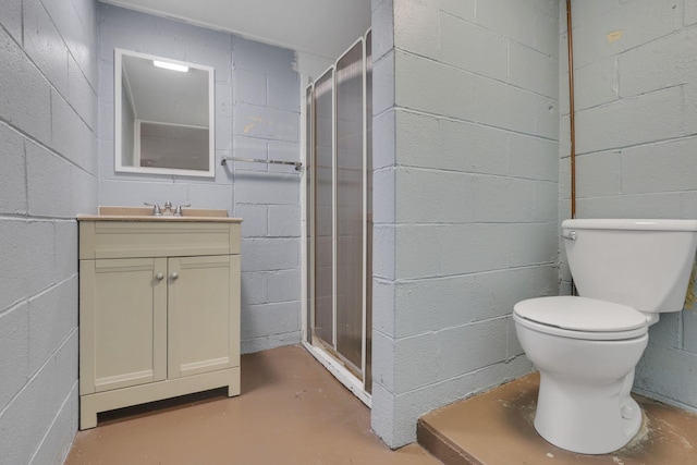 full bathroom featuring concrete flooring, concrete block wall, a stall shower, and vanity